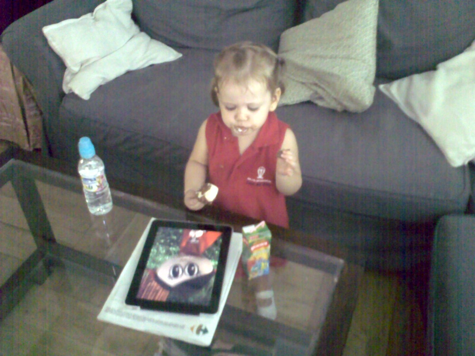 As a toddler on the sofa, looking at a tablet