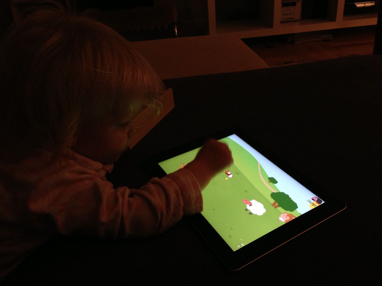 Playing with a tablet in the dark, lit by the screen