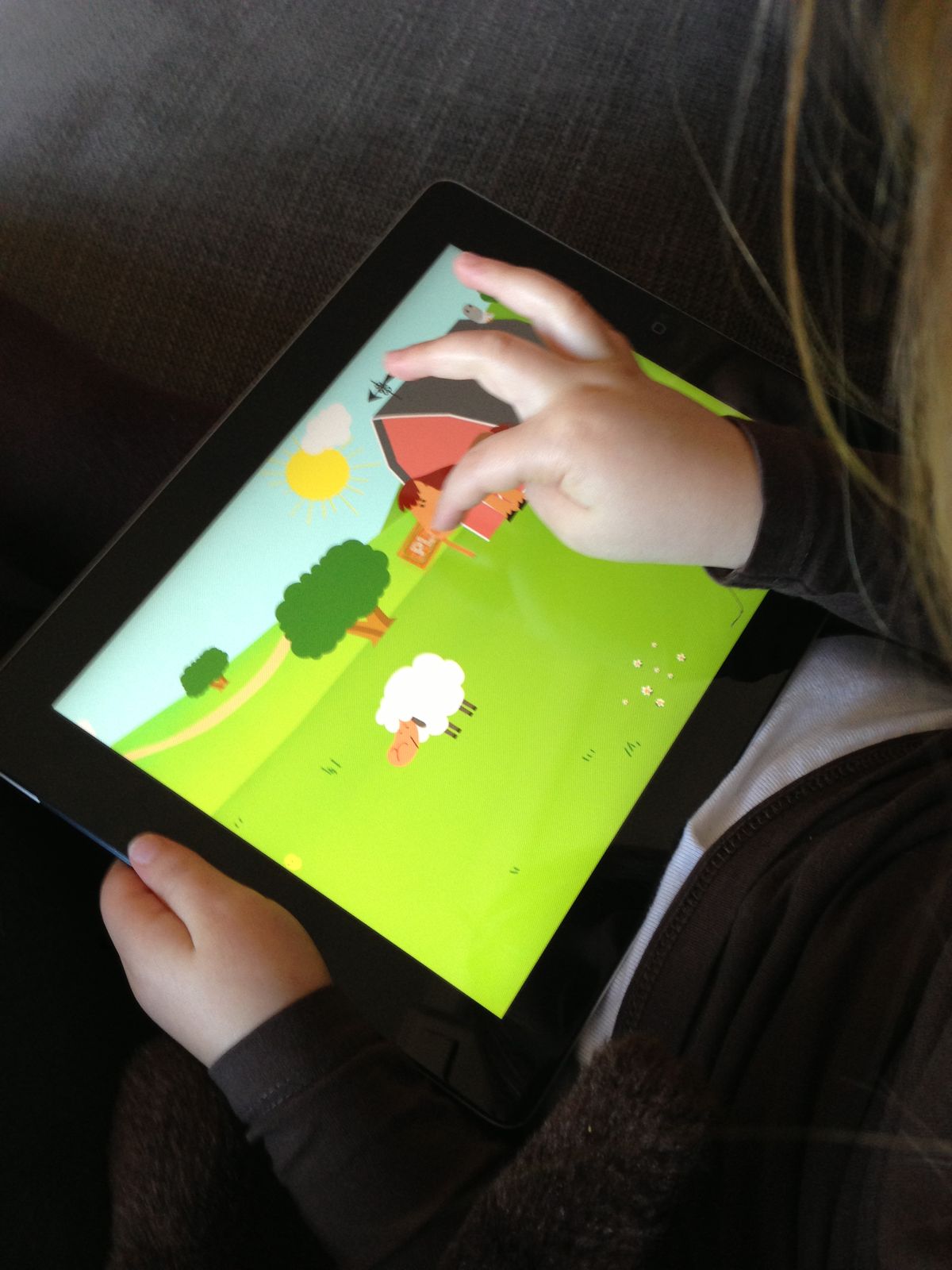 My hands tapping a farm game on the tablet
