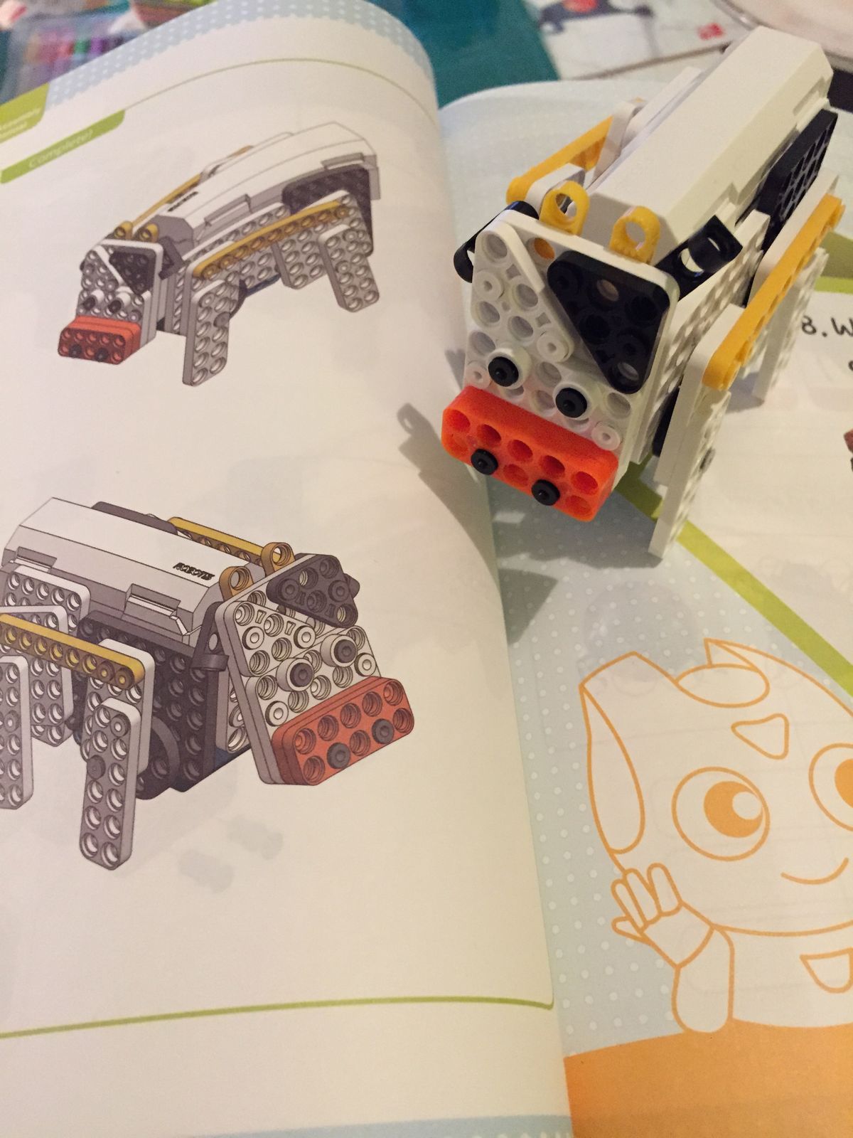 A brick robot cow next to its instructions in the manual
