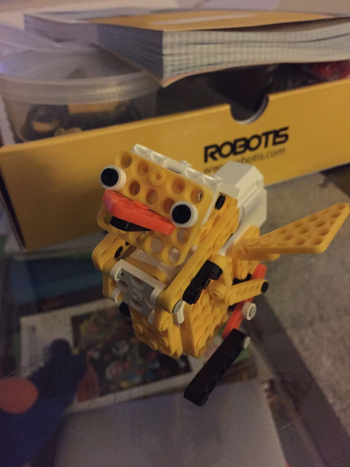 A yellow robot duck in front of the Robotis box
