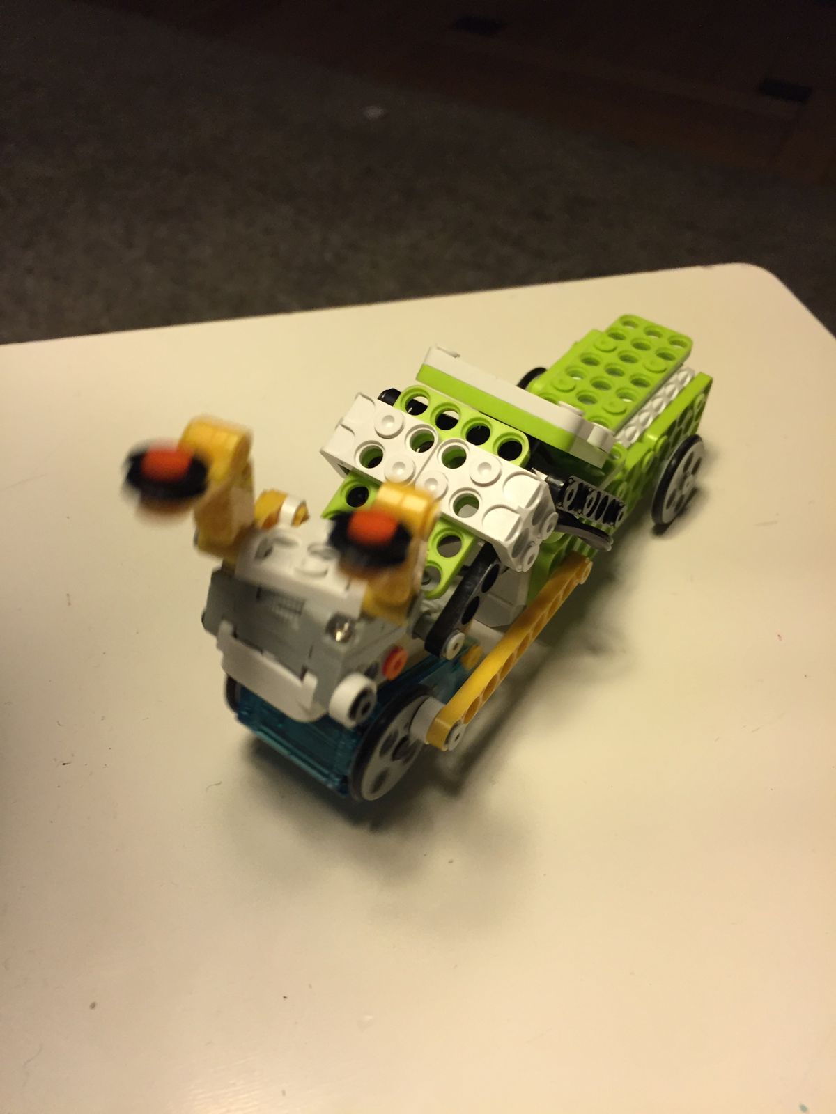 A green robot car with wheels and spinning arms